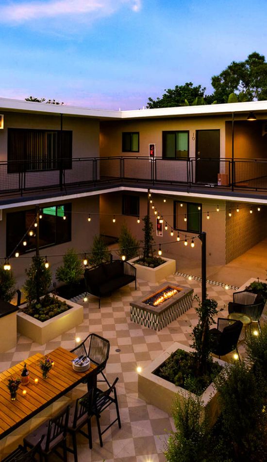 Apartments in West Hollywood; Birds-eye-view of Ollie on Ogden's courtyard decorated with string lights during the evening