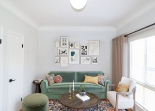 Gallery wall overlooking the velvet couch, an armchair and an ottoman with a table in between