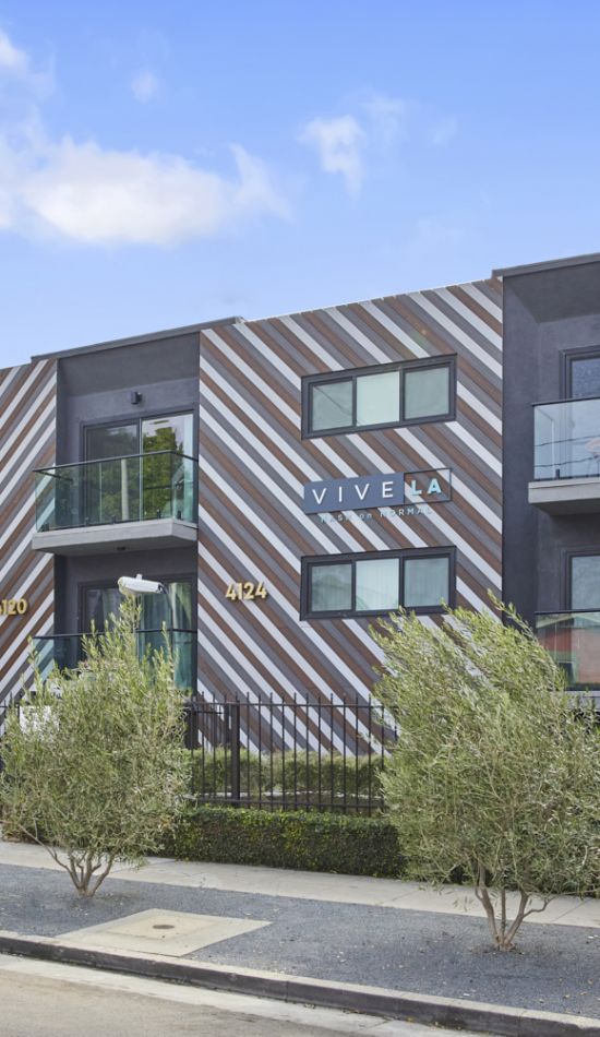 Nash on Normal building front with garden beds and tall trees