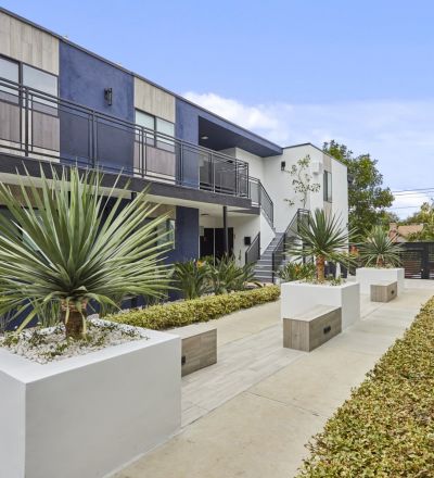 Courtyard area with cement potted plants next to garden beds at Callie on Curson building