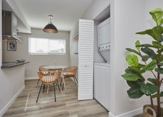 Apartment dining area with laundry in the closet and kitchen on the other side