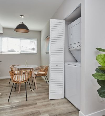 Apartment dining area with laundry in the closet and kitchen on the other side