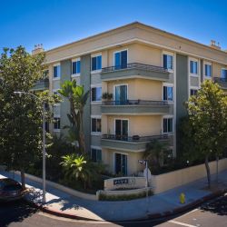 Exterior of Beverly Arnaz apartment building in a tree-lined street