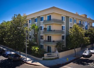 Exterior of Beverly Arnaz apartment building in a tree-lined street