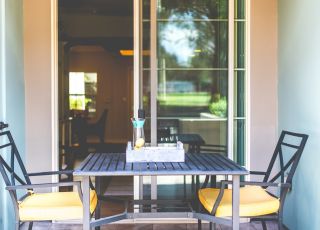 Dark washed wooden table with chairs at Park Encino apartment's patio area