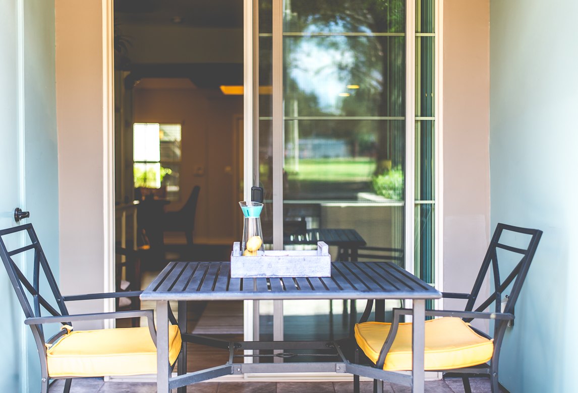Dark washed wooden table with chairs at Park Encino apartment's patio area