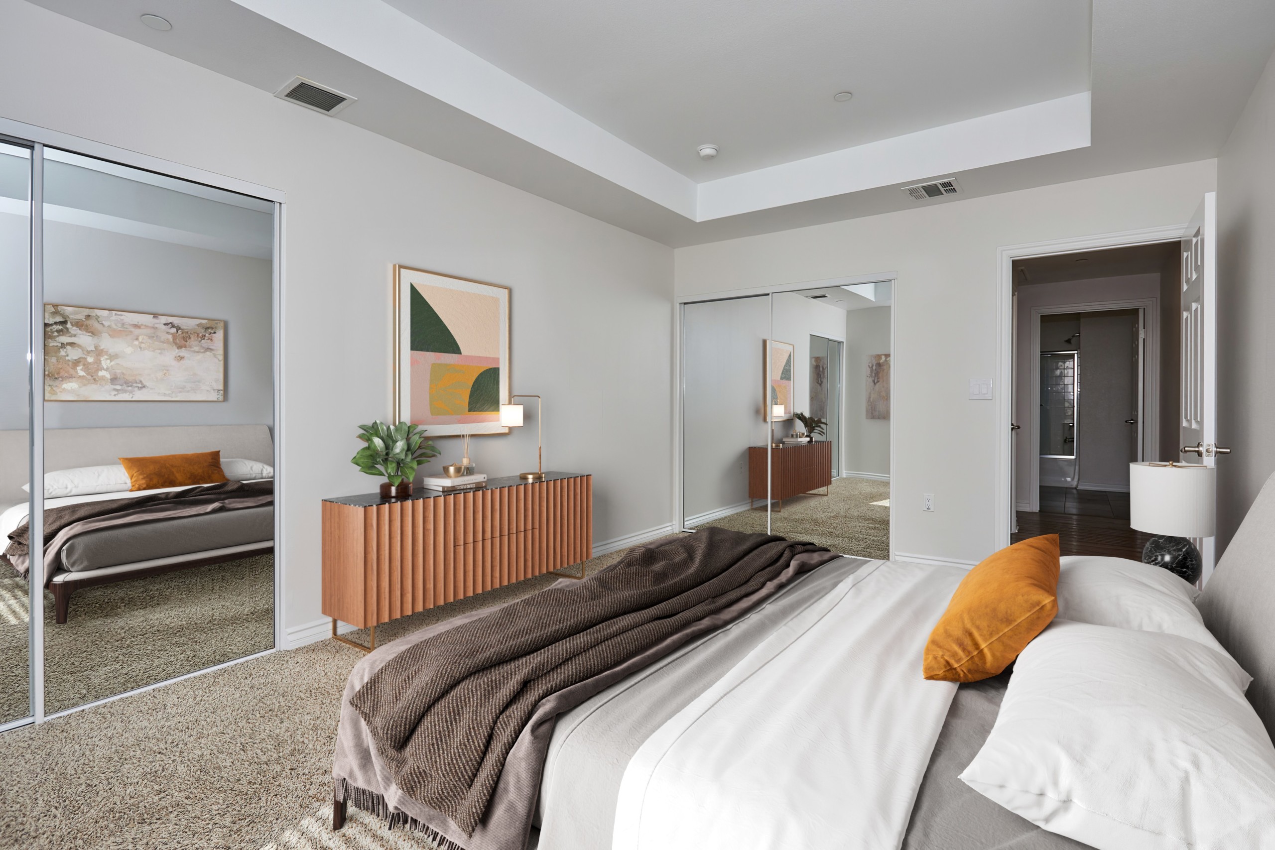 Spacious bed with duvet, sheets and pillows overlooking the dresser and mirror sliding door closets at Park Encino bedroom