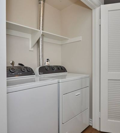 Laundry closet with washer and dryer lined together at Park Encino apartments