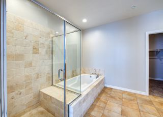 Marbled bathtub next to a glass-enclosed shower stall