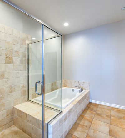 Marbled bathtub next to a glass-enclosed shower stall