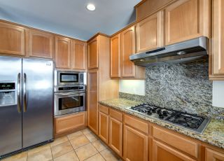 Marble kitchen stove countertop with wooden cabinets and stainless steel kitchen appliances
