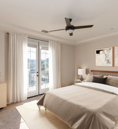Wooden bed frame with cushions and duvet next to side tables and dressers at Rancho Serrano's bedroom
