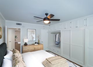 Large spacious bed with velvet headboard, pillows overlooking white wooden closet doors at Sage on Sweetzer bedrooms