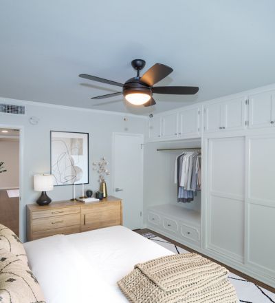 Large spacious bed with velvet headboard, pillows overlooking white wooden closet doors at Sage on Sweetzer bedrooms