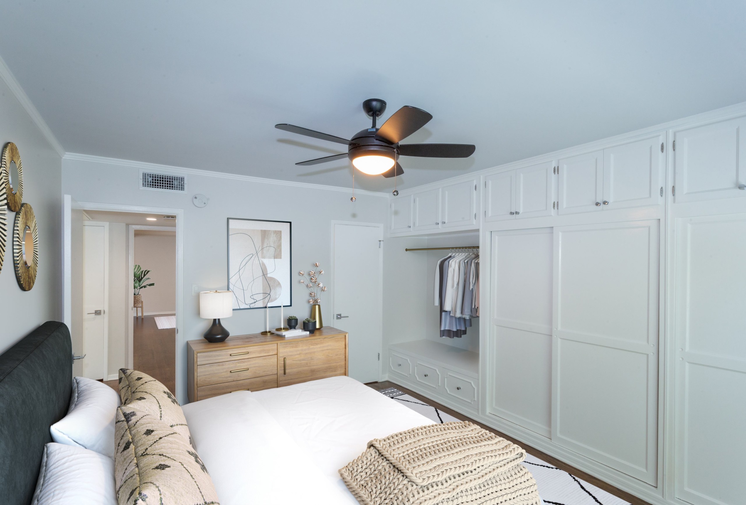 Large spacious bed with velvet headboard, pillows overlooking white wooden closet doors at Sage on Sweetzer bedrooms