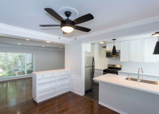 Wide kitchen counter with white cabinets and stainless steel kitchen appliances at Sage on Sweetzer apartments