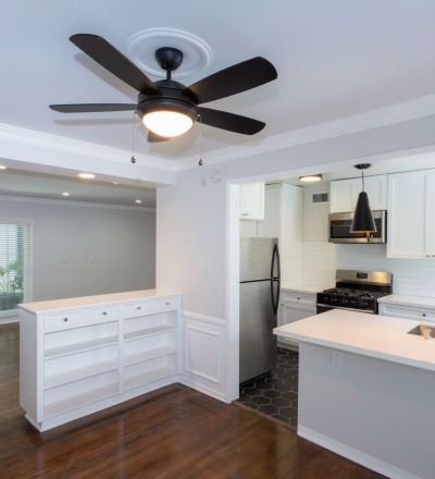 Wide kitchen counter with white cabinets and stainless steel kitchen appliances at Sage on Sweetzer apartments
