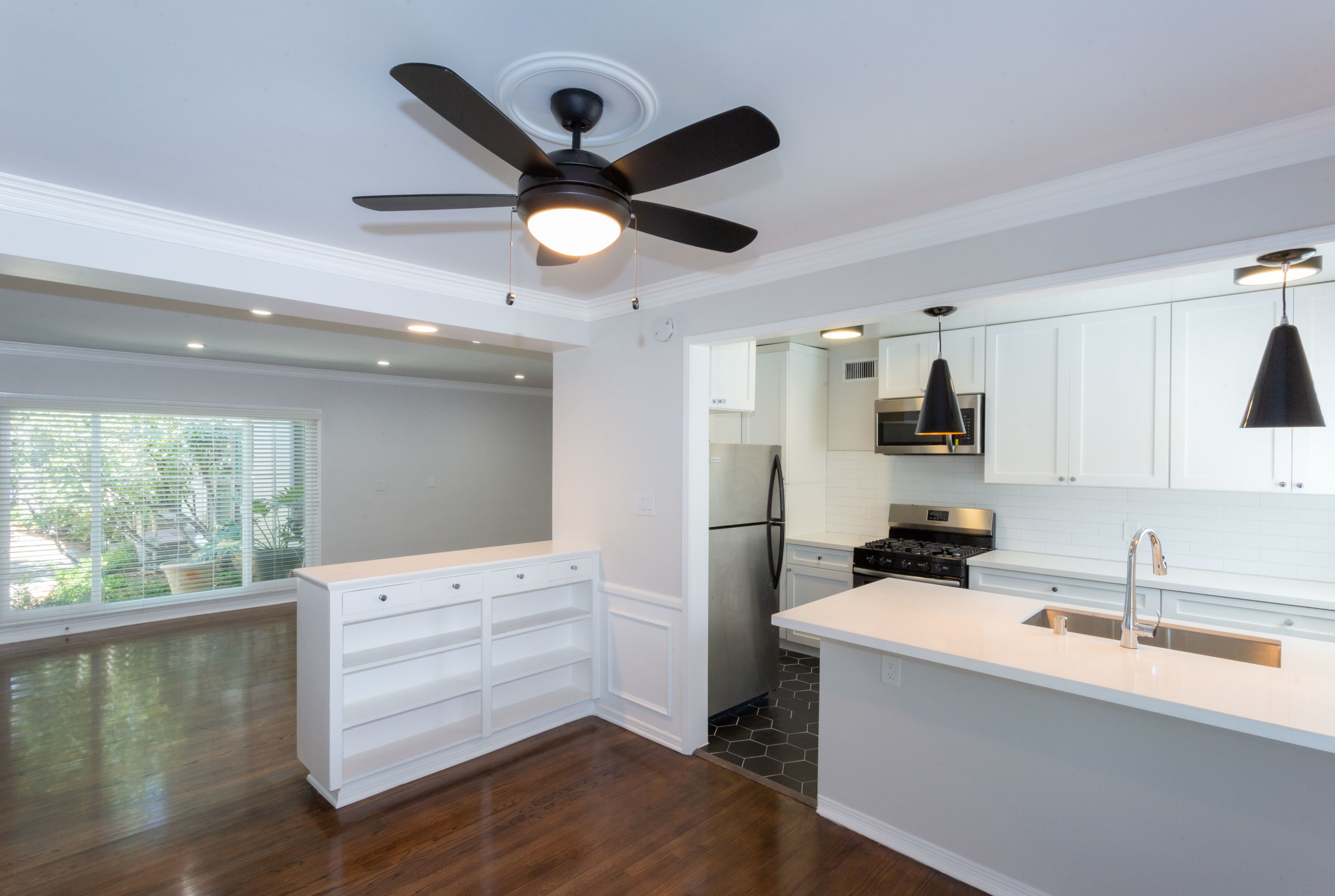 Wide kitchen counter with white cabinets and stainless steel kitchen appliances at Sage on Sweetzer apartments