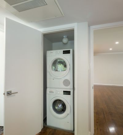 Laundry closet with washer and dryer stacked together at Sage on Sweetzer apartment