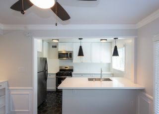Kitchen sink countertop overlooking the white cabinets, oven and fridge at Sage on Sweetzer