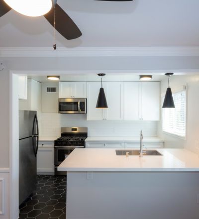 Kitchen sink countertop overlooking the white cabinets, oven and fridge at Sage on Sweetzer