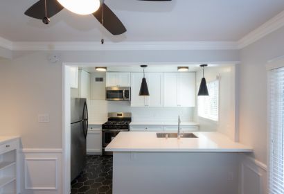 Kitchen sink countertop overlooking the white cabinets, oven and fridge at Sage on Sweetzer