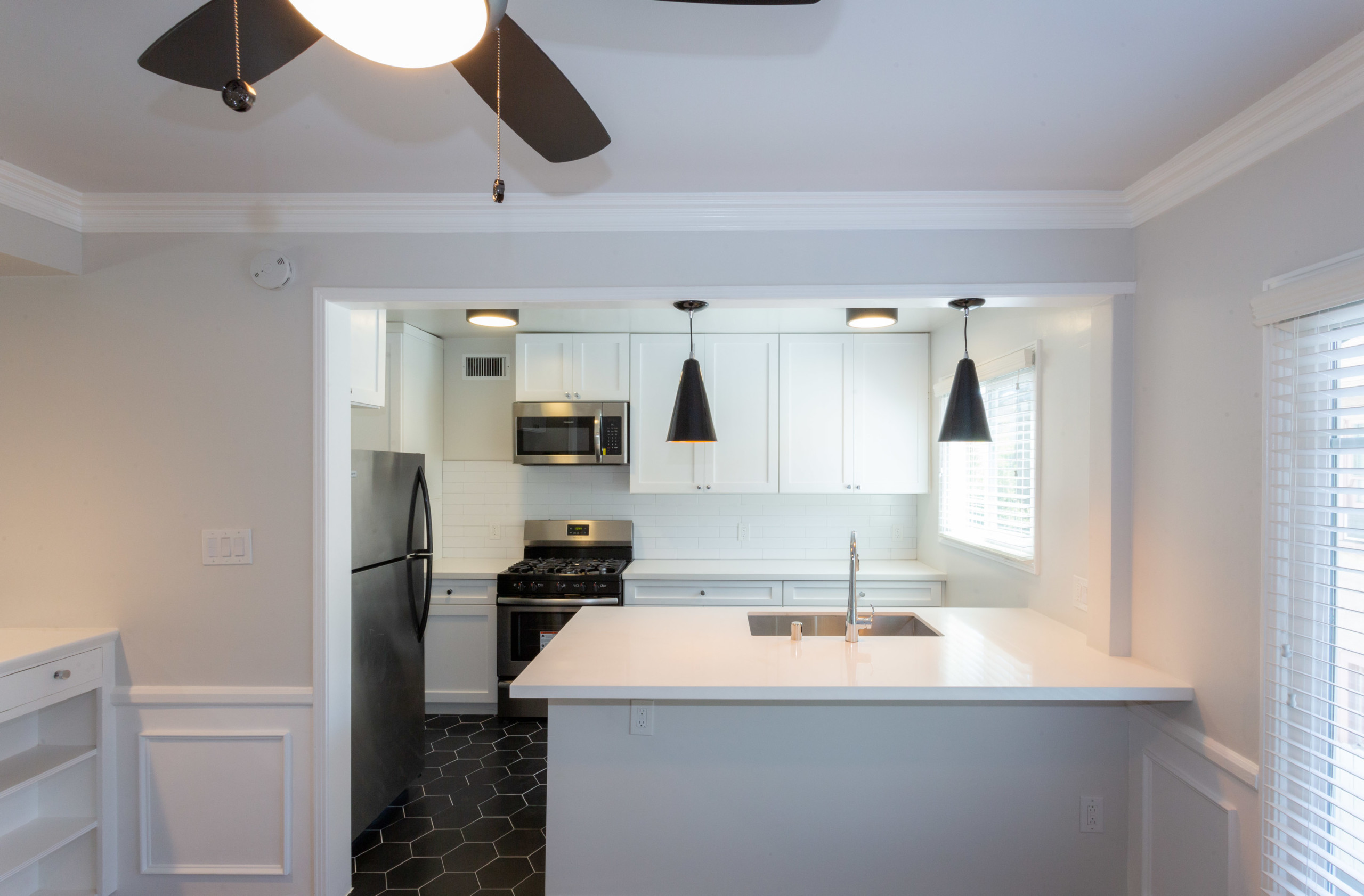 Kitchen sink countertop overlooking the white cabinets, oven and fridge at Sage on Sweetzer