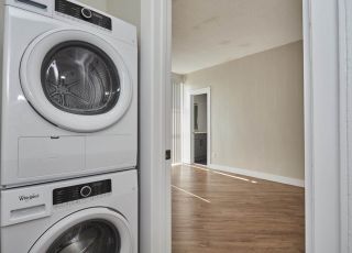 Laundry room with washer and dryer stacked together next to the bedroom area