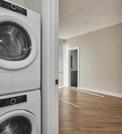 Laundry room with washer and dryer stacked together next to the bedroom area