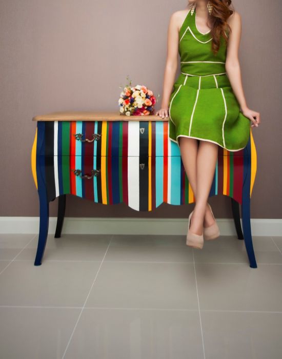 woman sitting on a colorful cabinet