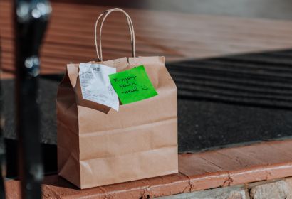 Paper bag with a green note and a receipt placed on a staircase