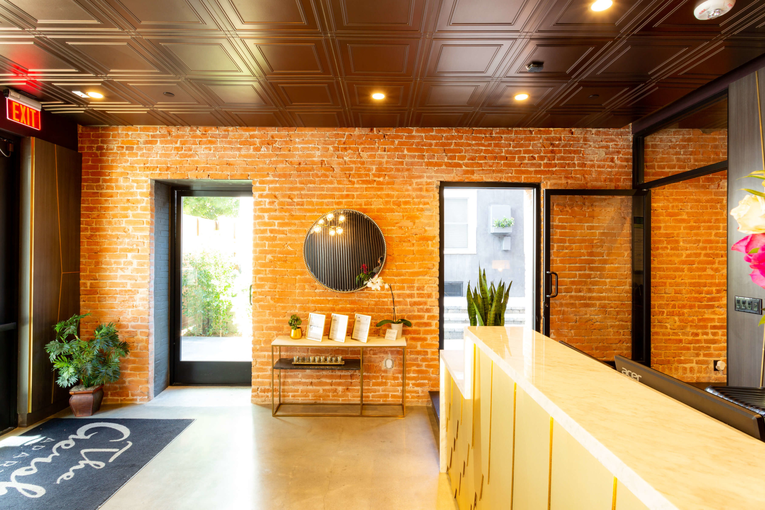 Textured lobby table overlooking the exposed brick wall at The Gershwin Apartmenrs Brick's lobby area