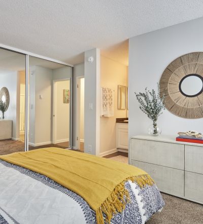 Violet on Virgil Apartments room; Bed overlooking the dresser with a mirror slider closer door on the side