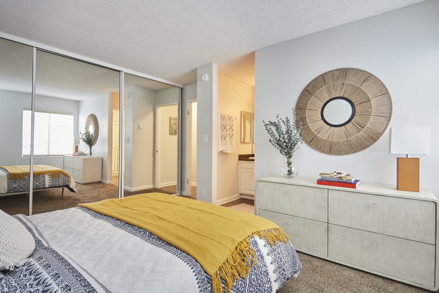 Violet on Virgil Apartments room; Bed overlooking the dresser with a mirror slider closer door on the side