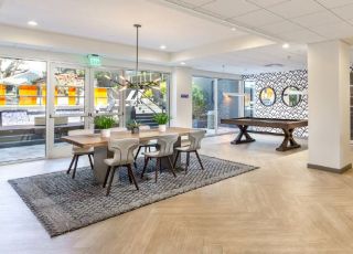 Communal space with table and chairs next to the pool table at Violet on Virgil Apartments