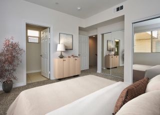 Spacious bed with pillows and comforters overlooking an en-suite bathroom