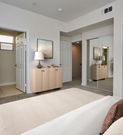 Spacious bed with pillows and comforters overlooking an en-suite bathroom