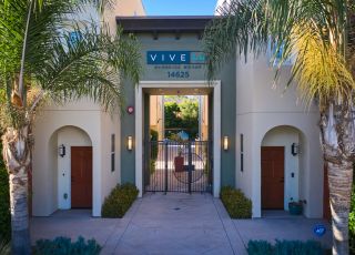Exterior to the Magnolia Woods townhouses with tall palm trees in the front