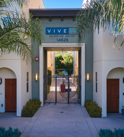 Exterior to the Magnolia Woods townhouses with tall palm trees in the front
