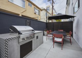 Outdoor barbecue machine placed next to the patio dining table and chairs