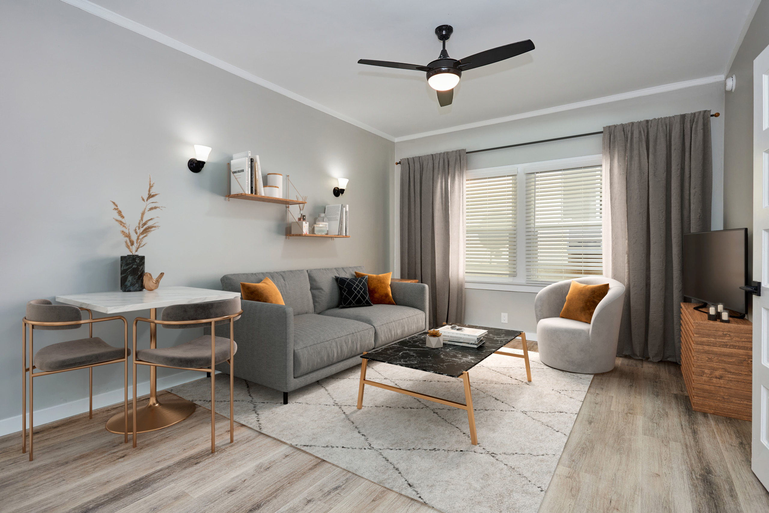 Grey couch with orange and black pillows overlooking a coffee table and an armchair; Luxury Hollywood Rentals; boutique community apartments in Hollywood
