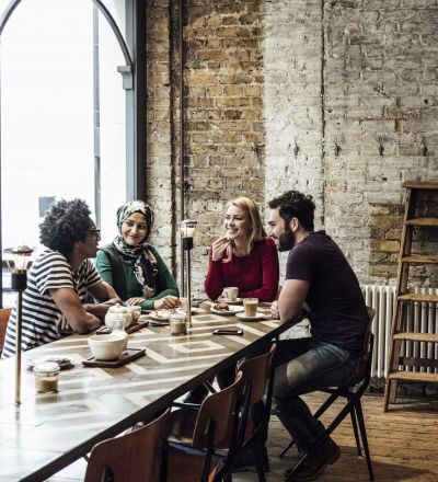 a group of friends at a table talking at a cafe near ViveLA apartments