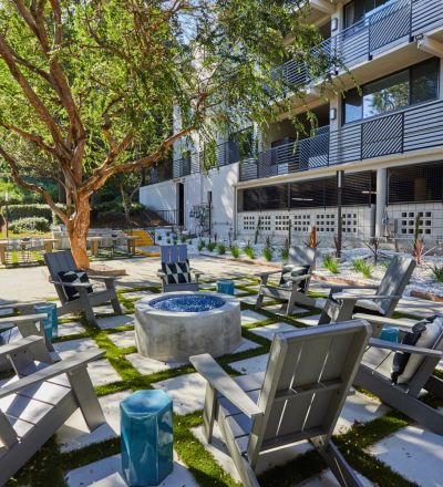 Outdoor fireplace with Adirondack chairs; Milo on Morton building exterior