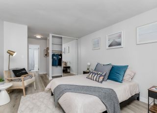 TheViolet On Virgil Apartments in LA; A cozy bedroom with a comfortable bed, a stylish dresser, and a sleek chair.