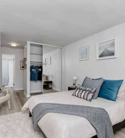 TheViolet On Virgil Apartments in LA; A cozy bedroom with a comfortable bed, a stylish dresser, and a sleek chair.