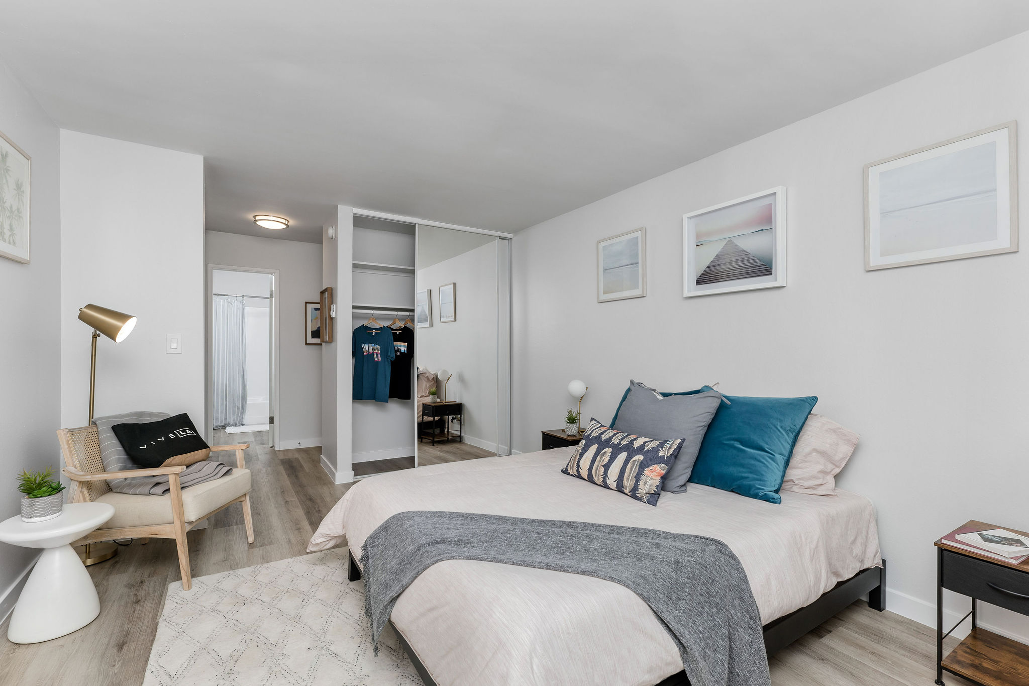 TheViolet On Virgil Apartments in LA; A cozy bedroom with a comfortable bed, a stylish dresser, and a sleek chair.