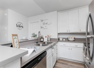 The Violet On Virgil Apartments in LA; A modern kitchen with sleek stainless steel appliances and warm wooden floors.