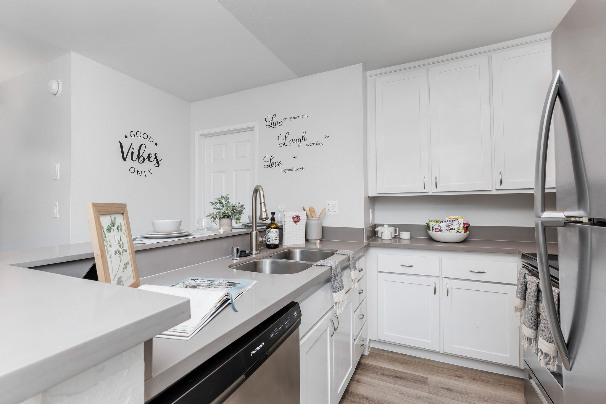 The Violet On Virgil Apartments in LA; A modern kitchen with sleek stainless steel appliances and warm wooden floors.