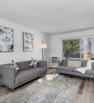 Violet On Virgil Apartments pet friendly rentals Los Angeles; A cozy living room with a comfortable couch, a stylish coffee table, and a large window offering natural light.