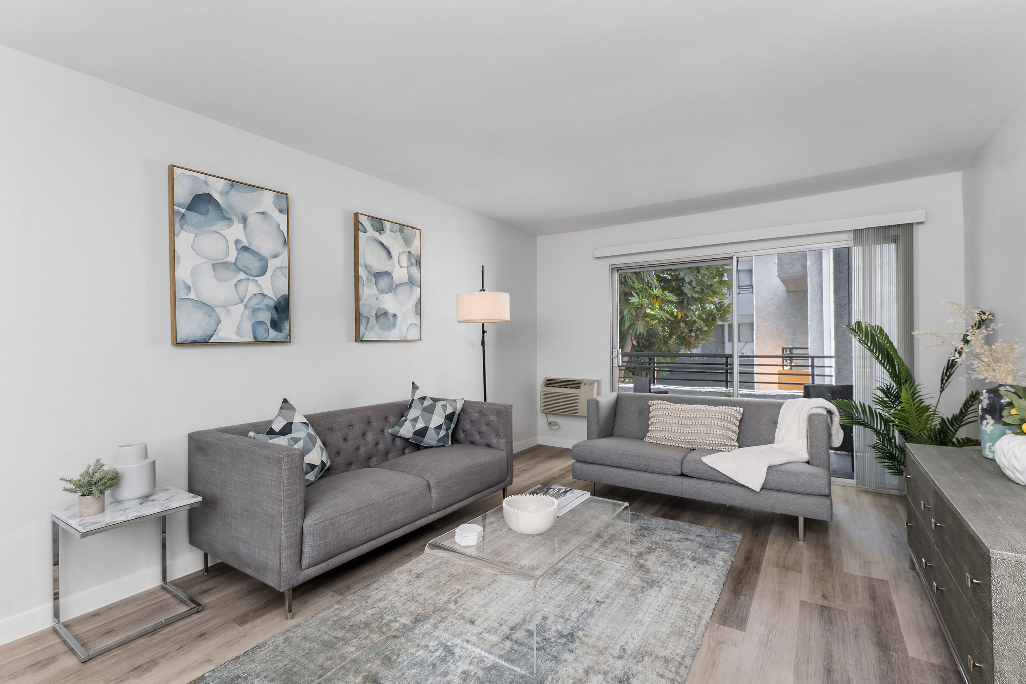 Violet On Virgil Apartments pet friendly rentals Los Angeles; A cozy living room with a comfortable couch, a stylish coffee table, and a large window offering natural light.